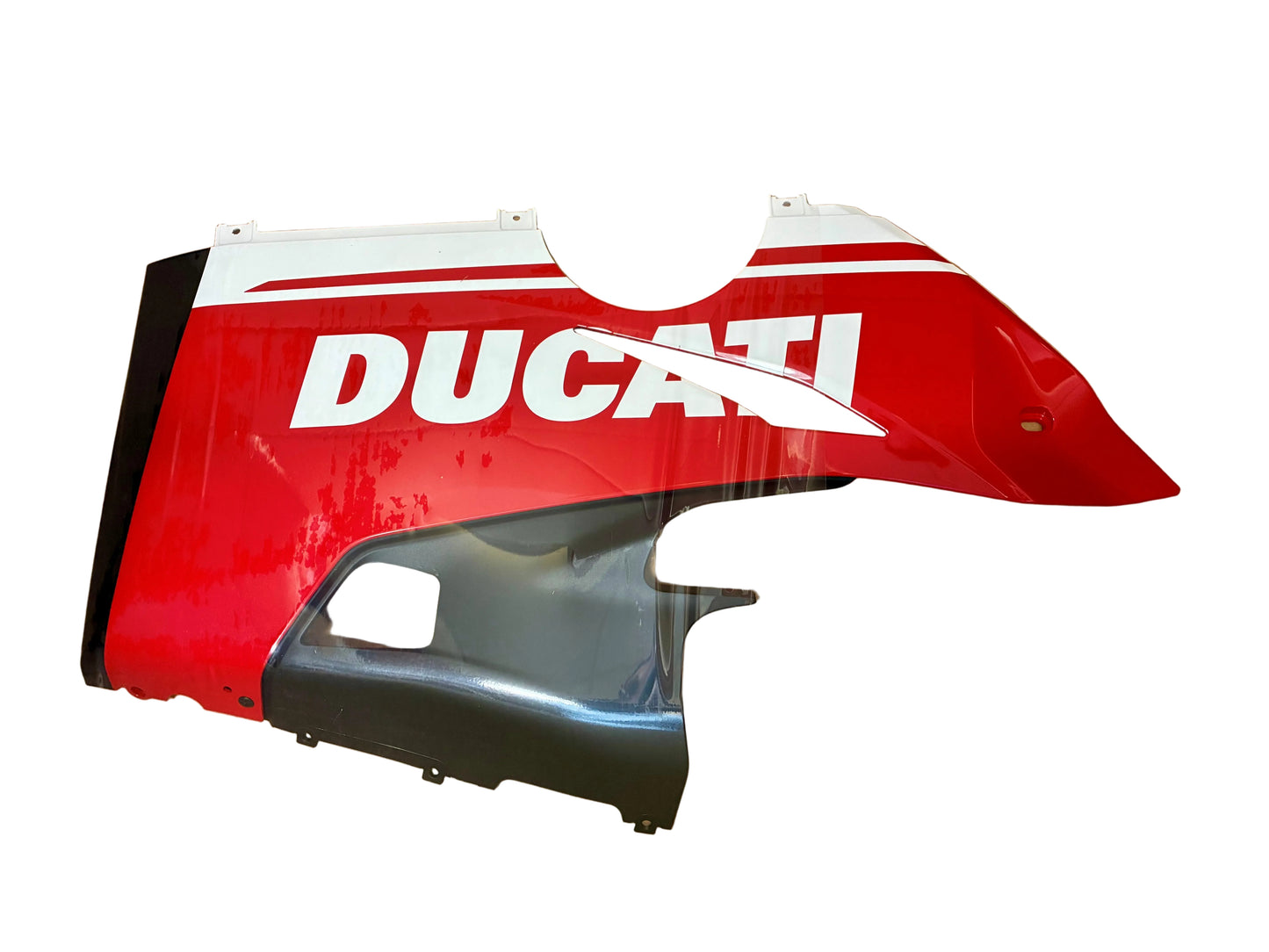 A red and white Ducati motorcycle fairing panel with the brand name 'DUCATI' in white, displayed inside a brown cardboard box alongside a black plastic component.